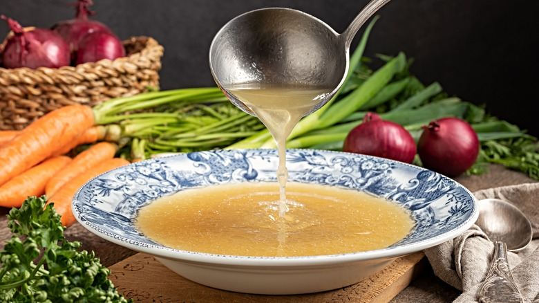 Ladle pouring stock into bowl