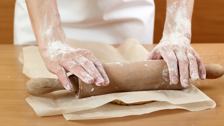 Rolling dough between parchment paper