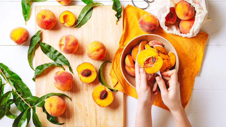 person cutting a peach