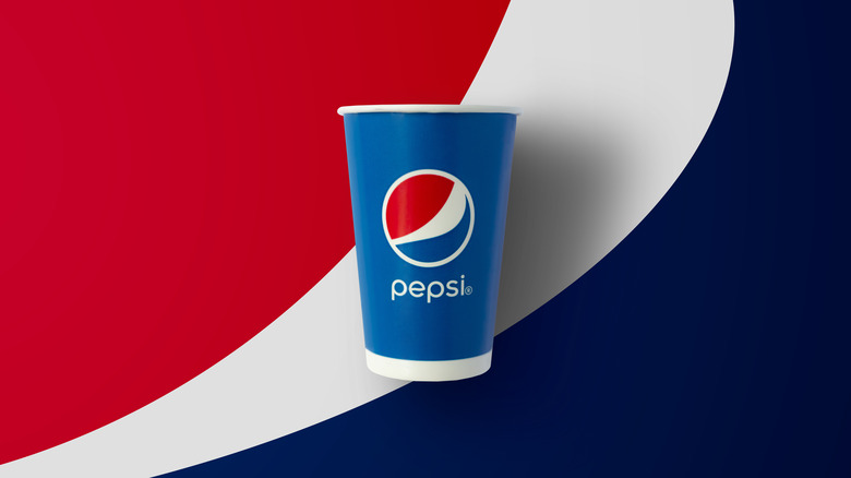 Pepsi paper cup against a backdrop of Pepsi colors