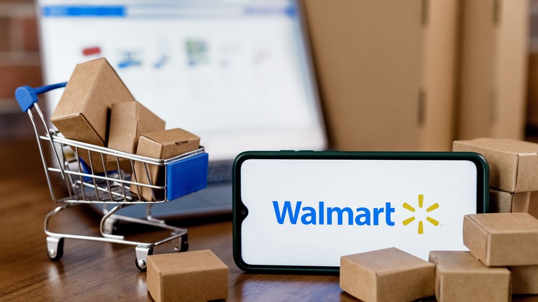 Walmart app on mobile phone and small shopping cart