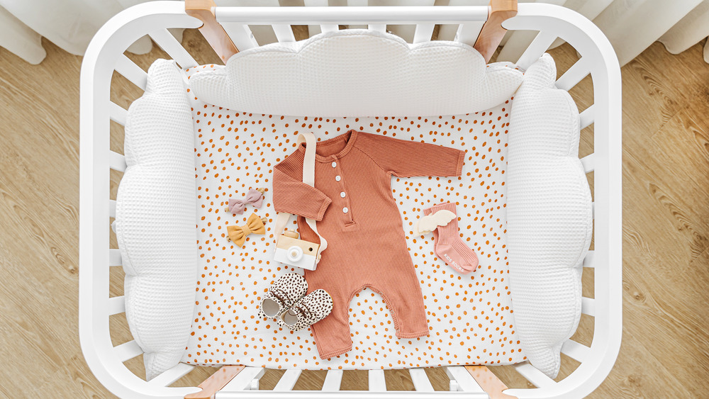 Baby clothes in a crib