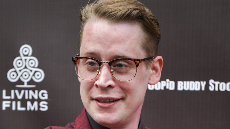 Macaulay Culkin smiling with glasses