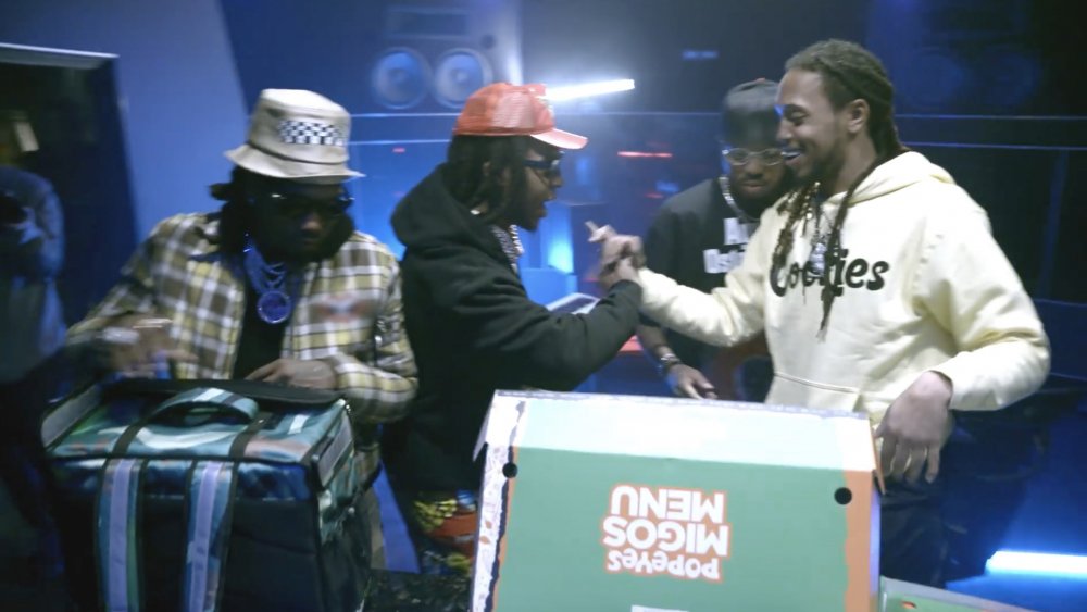 Migos with a box containing their collaboration meal with Popeyes