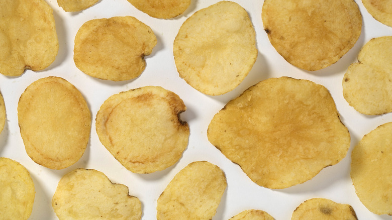 Individual potato chips on a white surface