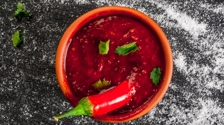 A chili dipped in spicy Mexican salsa
