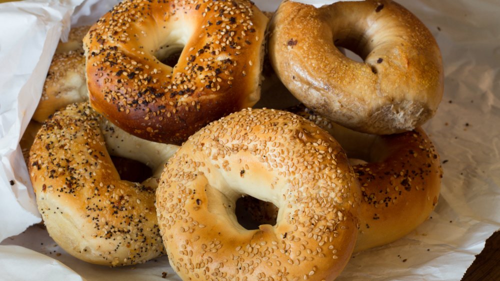 variety of New York bagels in a white paper bag