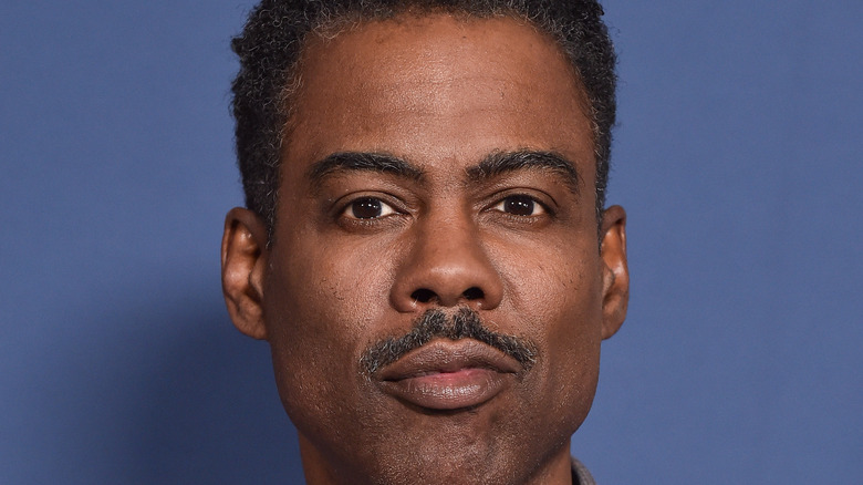 Chris Rock in front of blue background