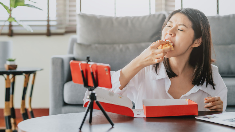 woman eating pastry on camera