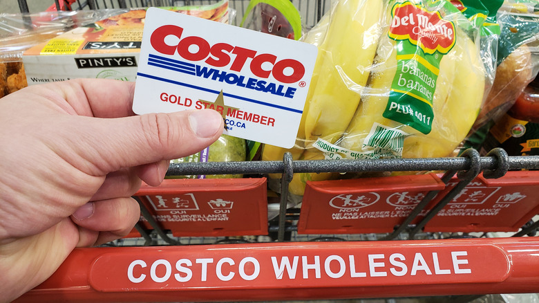 costco cart with member holding costco card