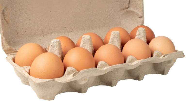 A dozen brown eggs in carton