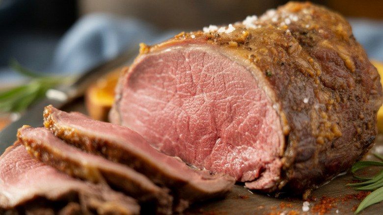 Roasted prime rib with some of it sliced.