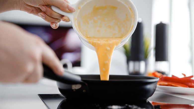 Pouring eggs for omelet