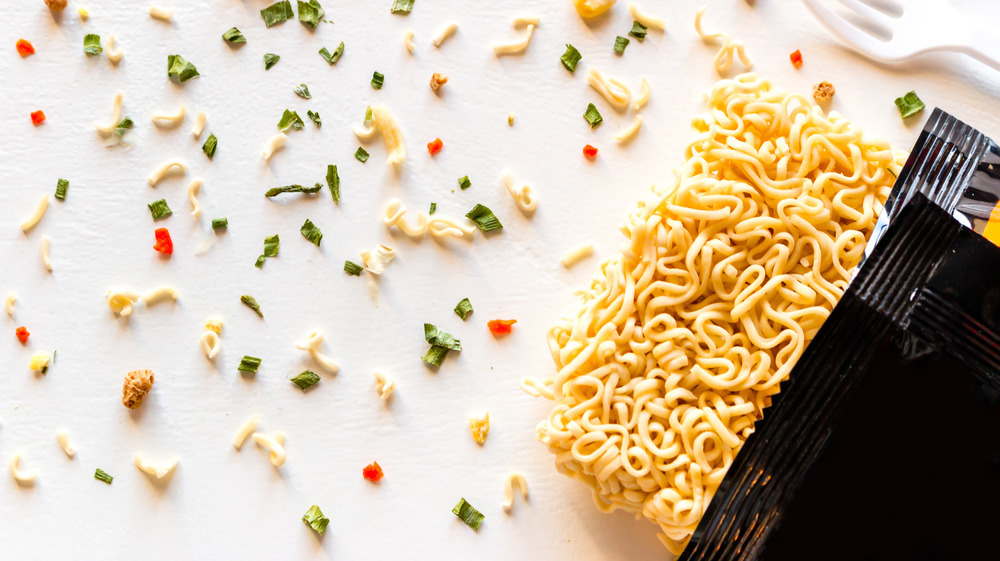 Ramen noodles in open black package with seasonings