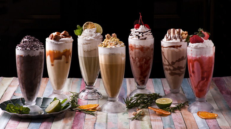 Variety of milkshakes lined up on a wooden table