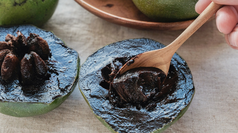 spooning out black sapote