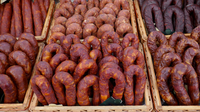 Variety of cured sausages in bins