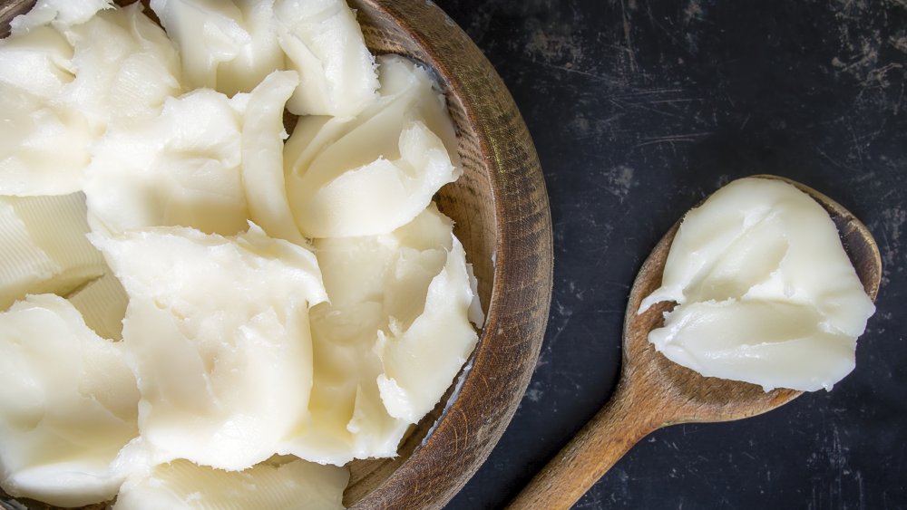 Wooden bowl filled with lard and spoon with lard