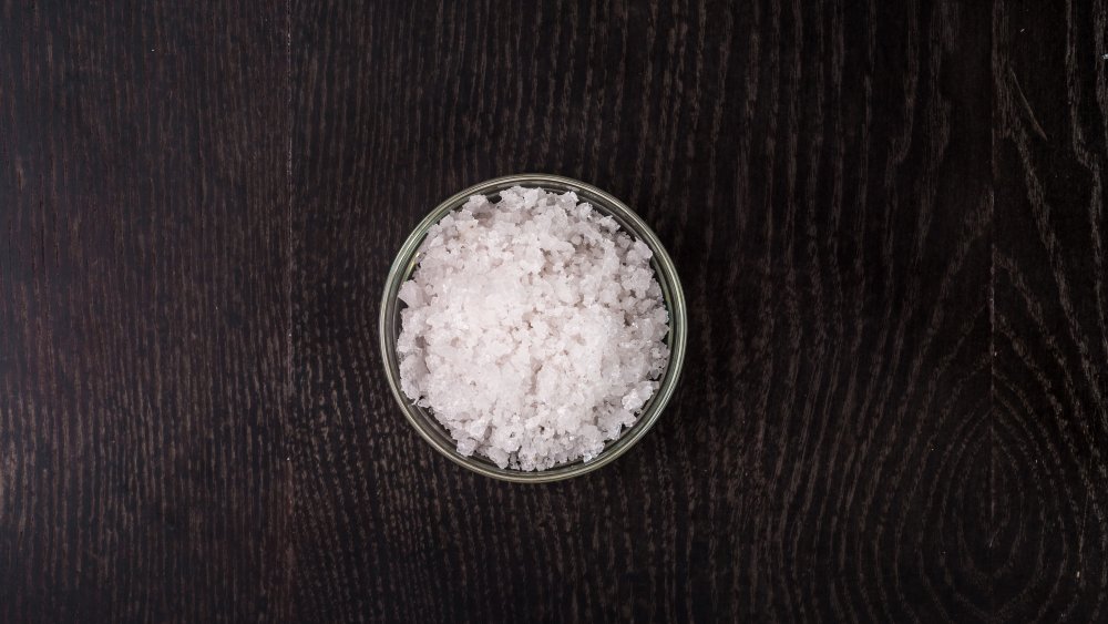 salt in a glass bowl on a black background