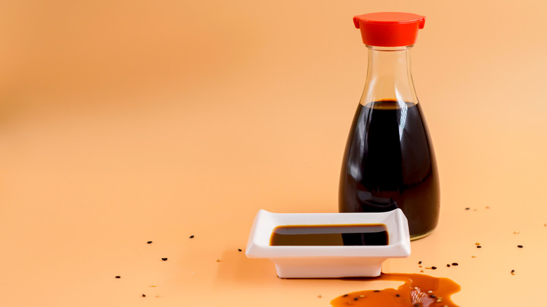 bottle of soy sauce with white dish of sauce
