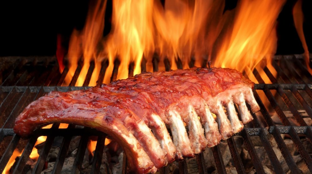 Babyback barbecued ribs on a hot charcoal grill.