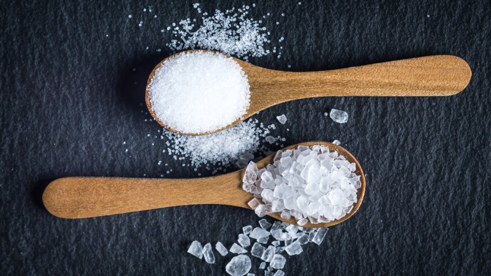 Sea salt and table salt in wooden spoons