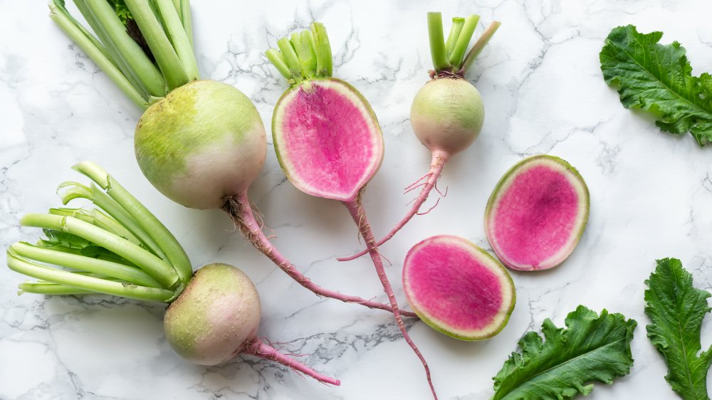 Whole and sliced watermelon radishes on counter