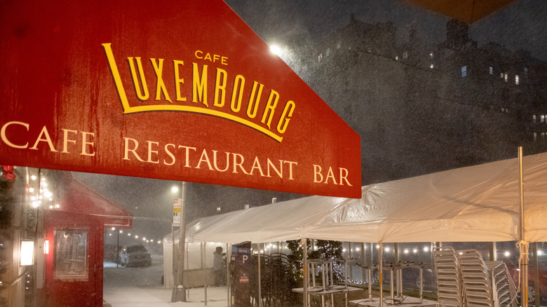 Exterior shot of Cafe Luxembourg during a snow storm in New York.