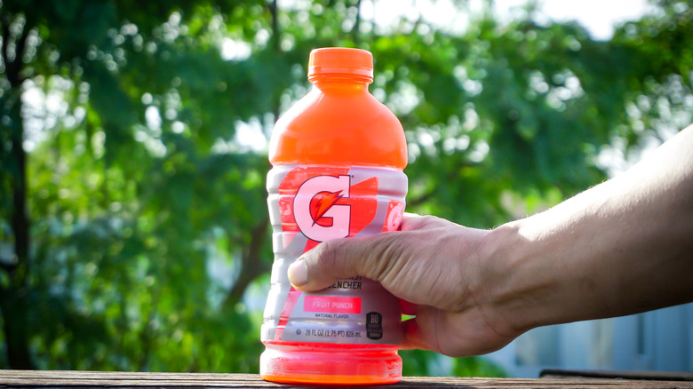 A hand holding a pink Gatorade bottle