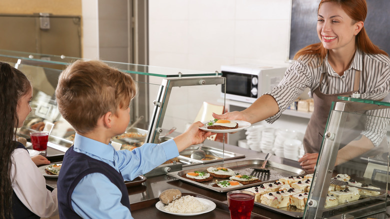 child being served lunch in a school cafeteria 