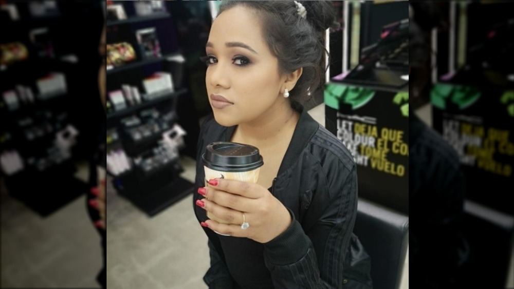 TV personality Natasha de Bourg in black holding a coffee cup