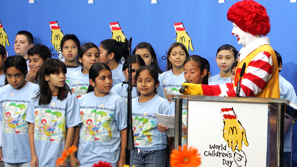 Ronald McDonald with a cluster of children that the charity he represents presumably assists. Many of them do not seem happy to be watched by a clown.