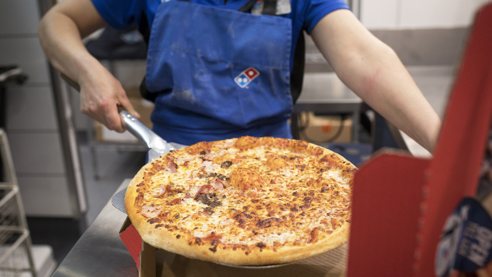 Domino's pizza being put in box