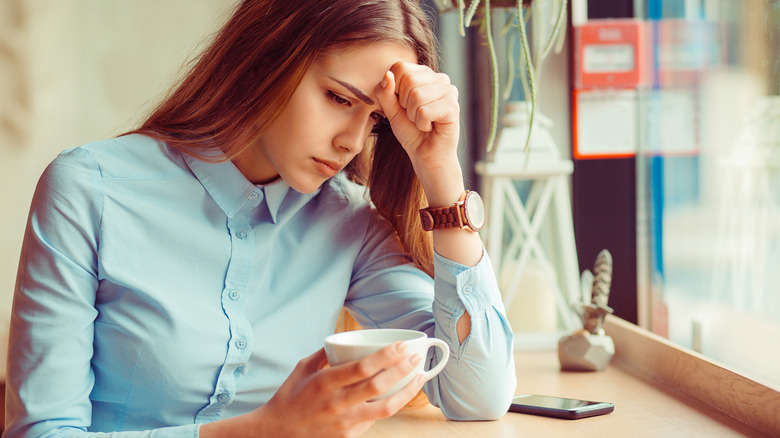 Woman with anxiety holding coffee