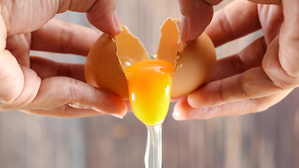 Hands cracking egg for cooking