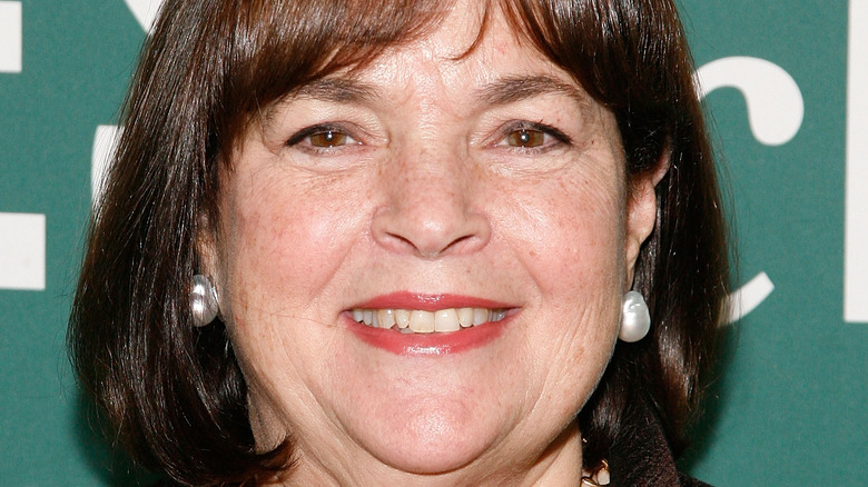 Ina Garten smiles with red lipstick and earrings