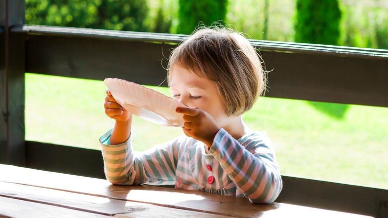 Girl slurping bowl of soup