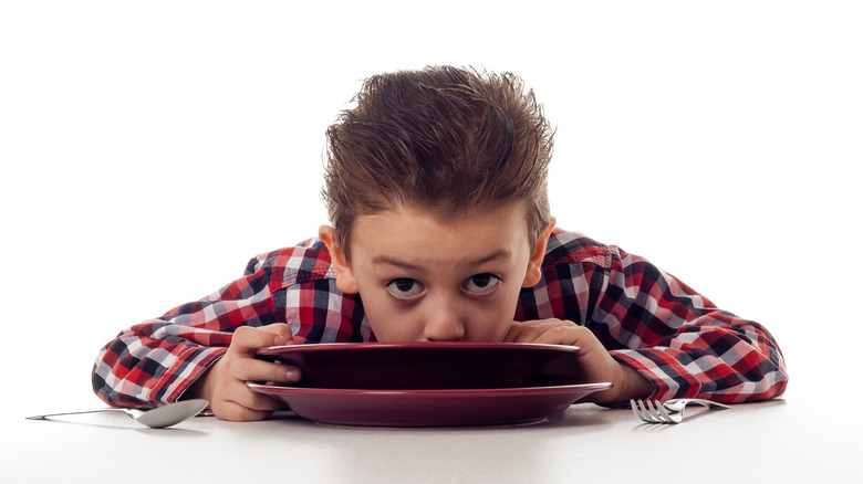 Boy slurping bowl of soup