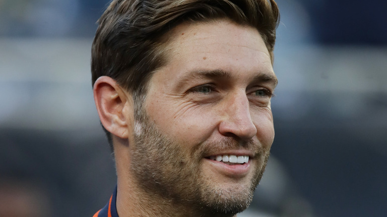 Jay Cutler smiles while watching a football game