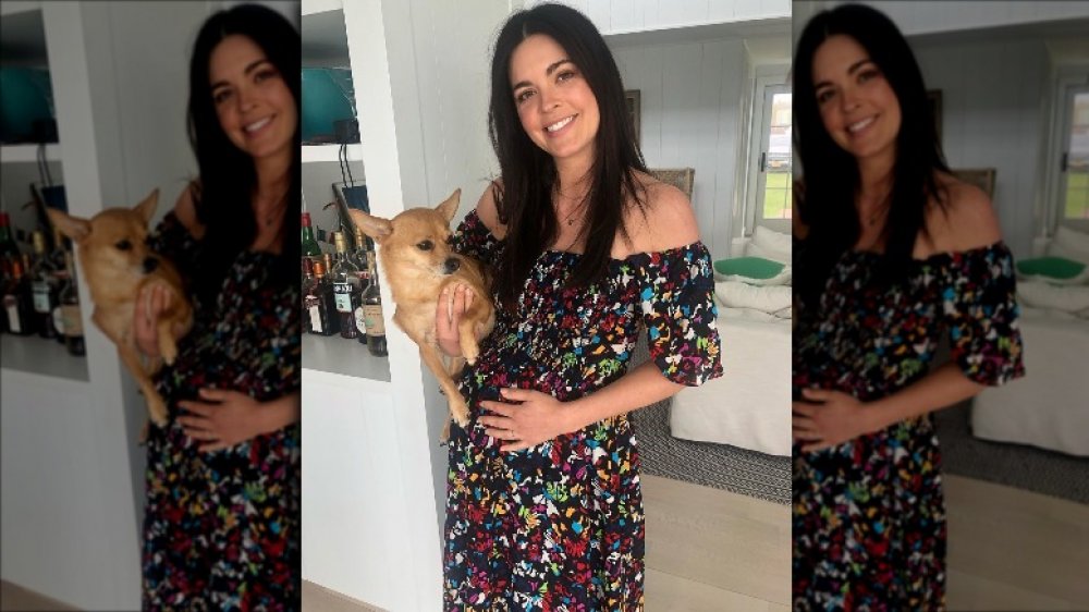 katie lee holding dog and cradling pregnant belly