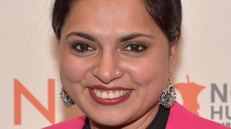 Maneet Chauhan smiling in pink top and earrings