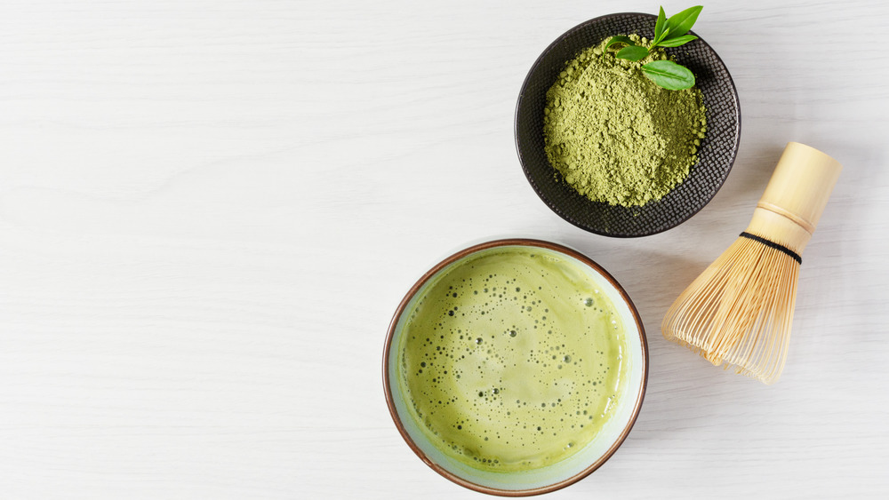 matcha powder in bowl with whisk and frothed