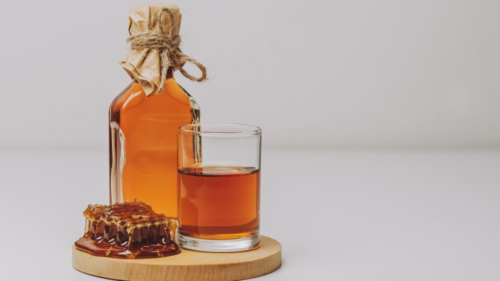 Mead on a board with a glass and honeycomb