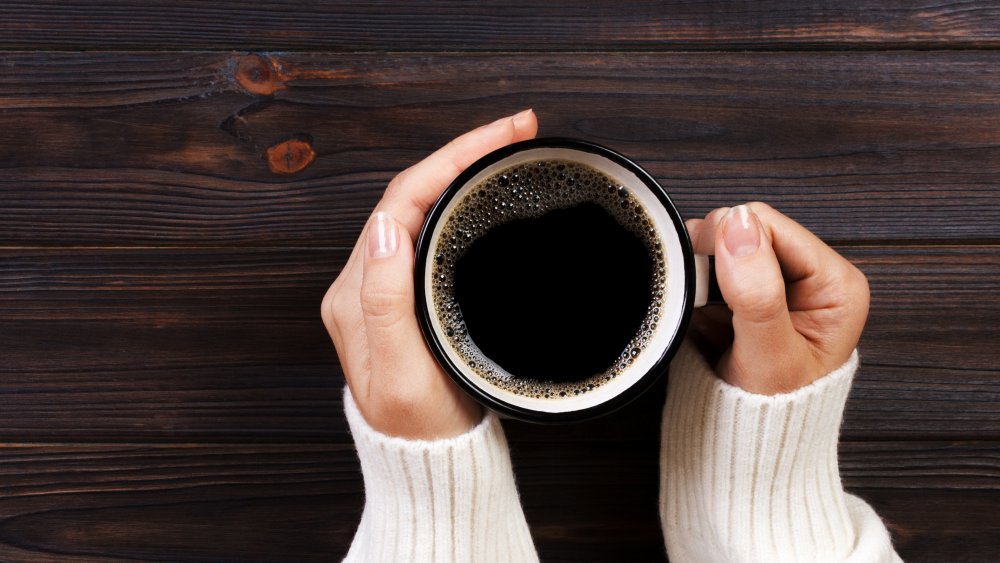 A generic image of a person holding a cup of coffee