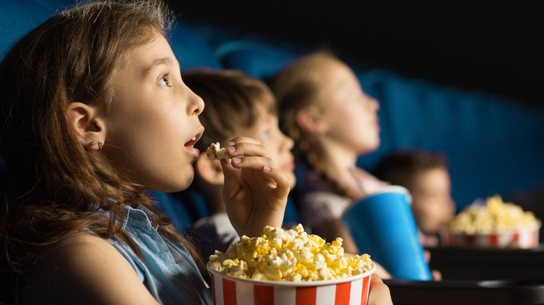 Kids watching movies, eating popcorn