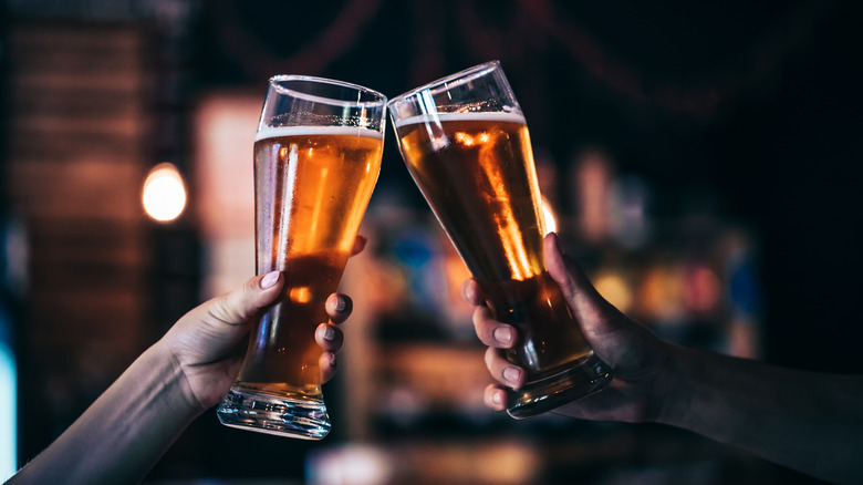 two beer pilsner glaases toasting