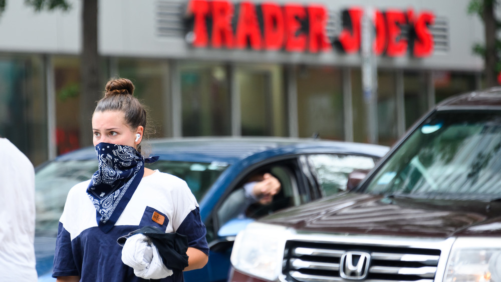 Woman wears face mask outside Trader Joe's