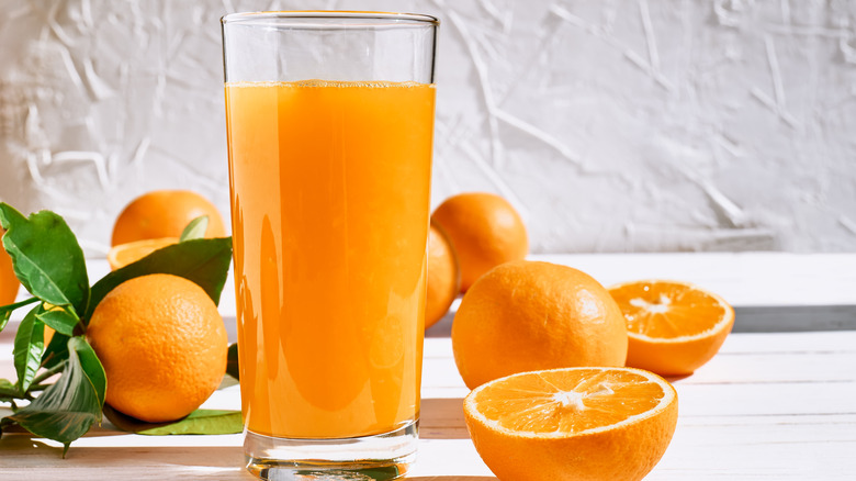 Orange juice next to oranges