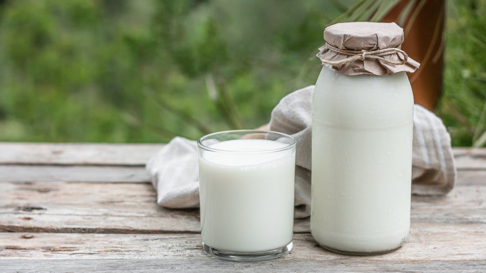 bottle and glass of organic milk on table