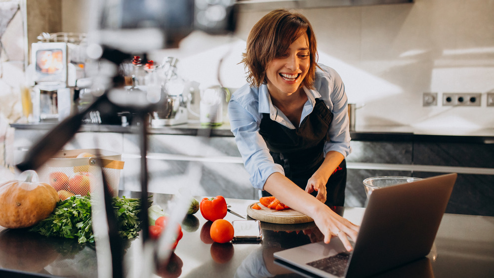 Woman cooking while blogging